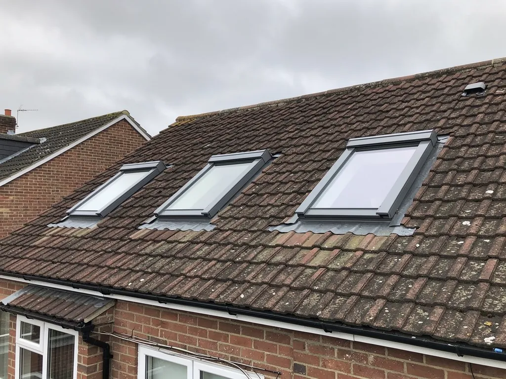 Three new roof windows in a tiled pitched roof